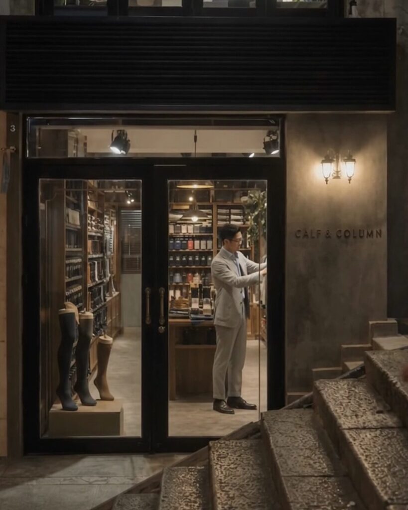 Calf & Column boutique at closing time, warmly lit beneath a Hong Kong residential building.